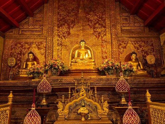 Le vénéré Bouddha Phra Singh veille sur la chapelle Lai Kam