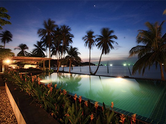 La piscine illuminée à la tombée de la nuit