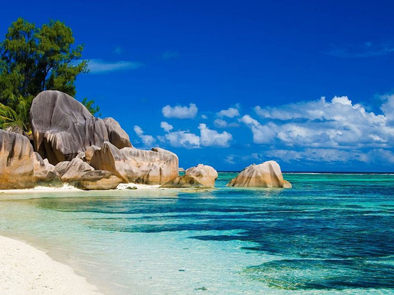 L'emblématique plage d'Anse Lazio dévoile son sable blanc parsemé de roches granitiques au bord d'une eau turquoise